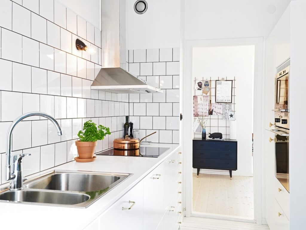 Keramisk och konkret backsplashdesign i det vita köket 
